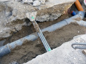 les tuyaux de la fibre optique sont à 35 cm du sol en milieu de rue, soit 15 cm de la surface avec leur protection, ce qui empêche de décaisser pour un écoulement central des eaux pluviales